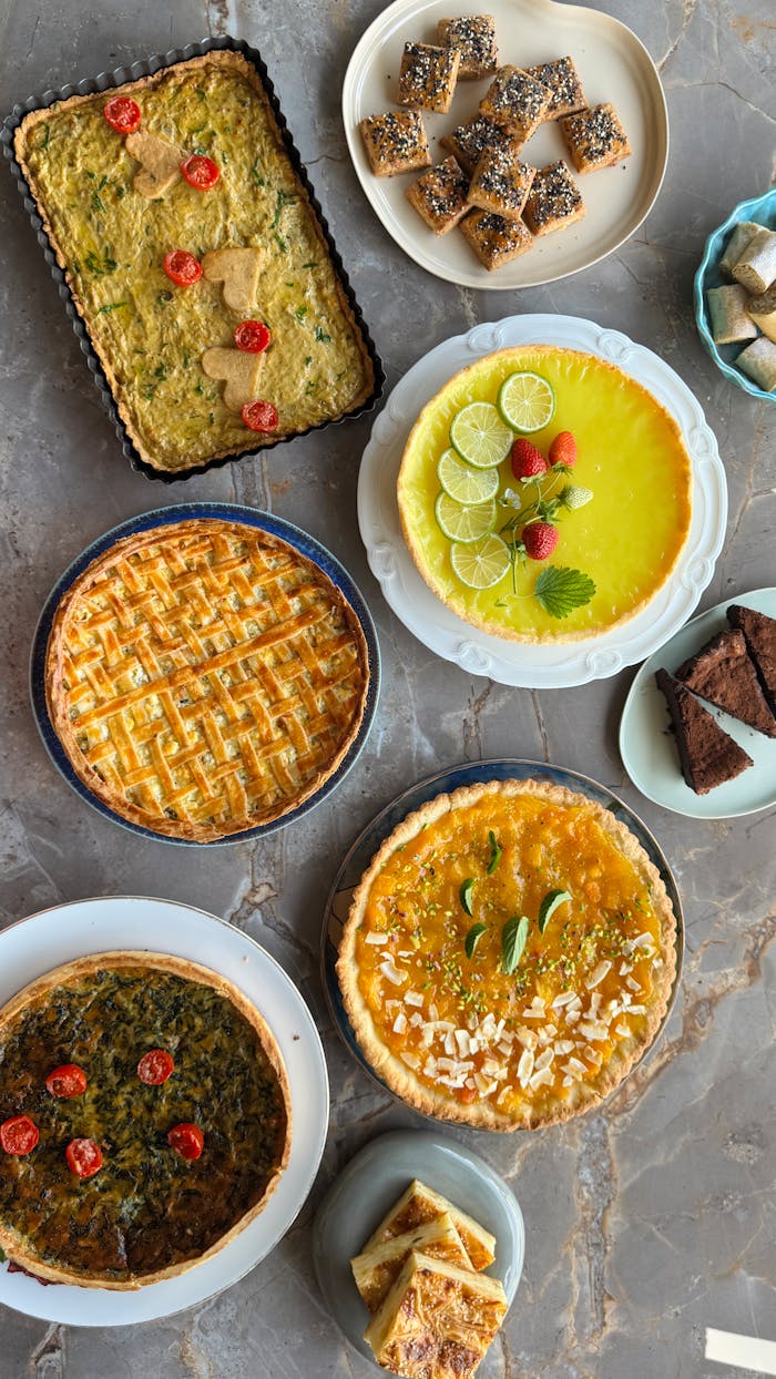 Colorful assortment of tarts and pastries on a marble surface, perfect for culinary inspiration.